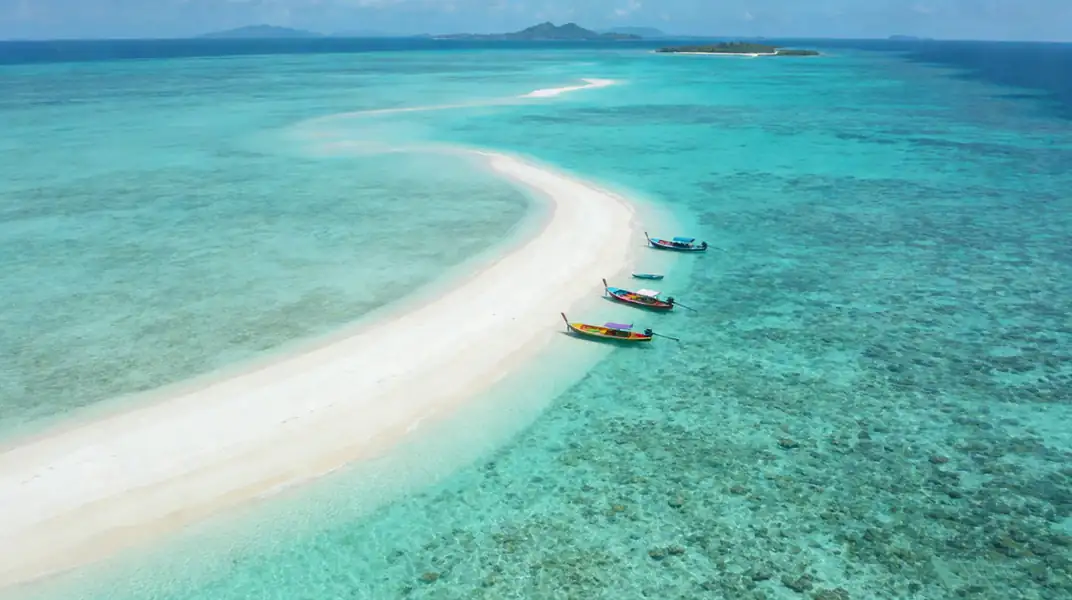 High angle drone shot of boats on an island tour Anyu Pool Villa Resort