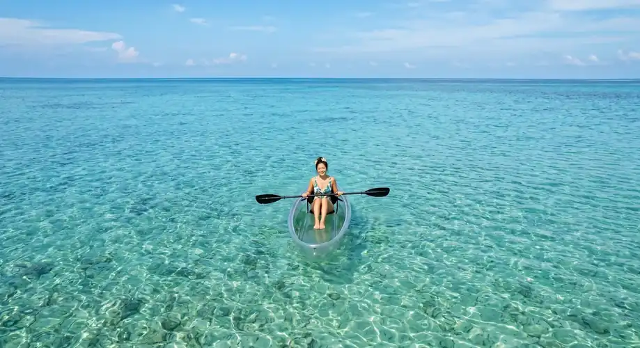 Paddling a kayak through the turquoise Semporna waters Anyu Pool Villa Resort